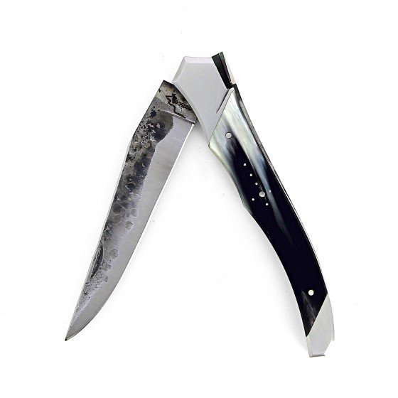 Ce couteau de Laguiole Tribal pliant est doté d'un manche de 12 cm en corne de vache Aubrac protégé par deux mitres inox, et de platines guillochées.