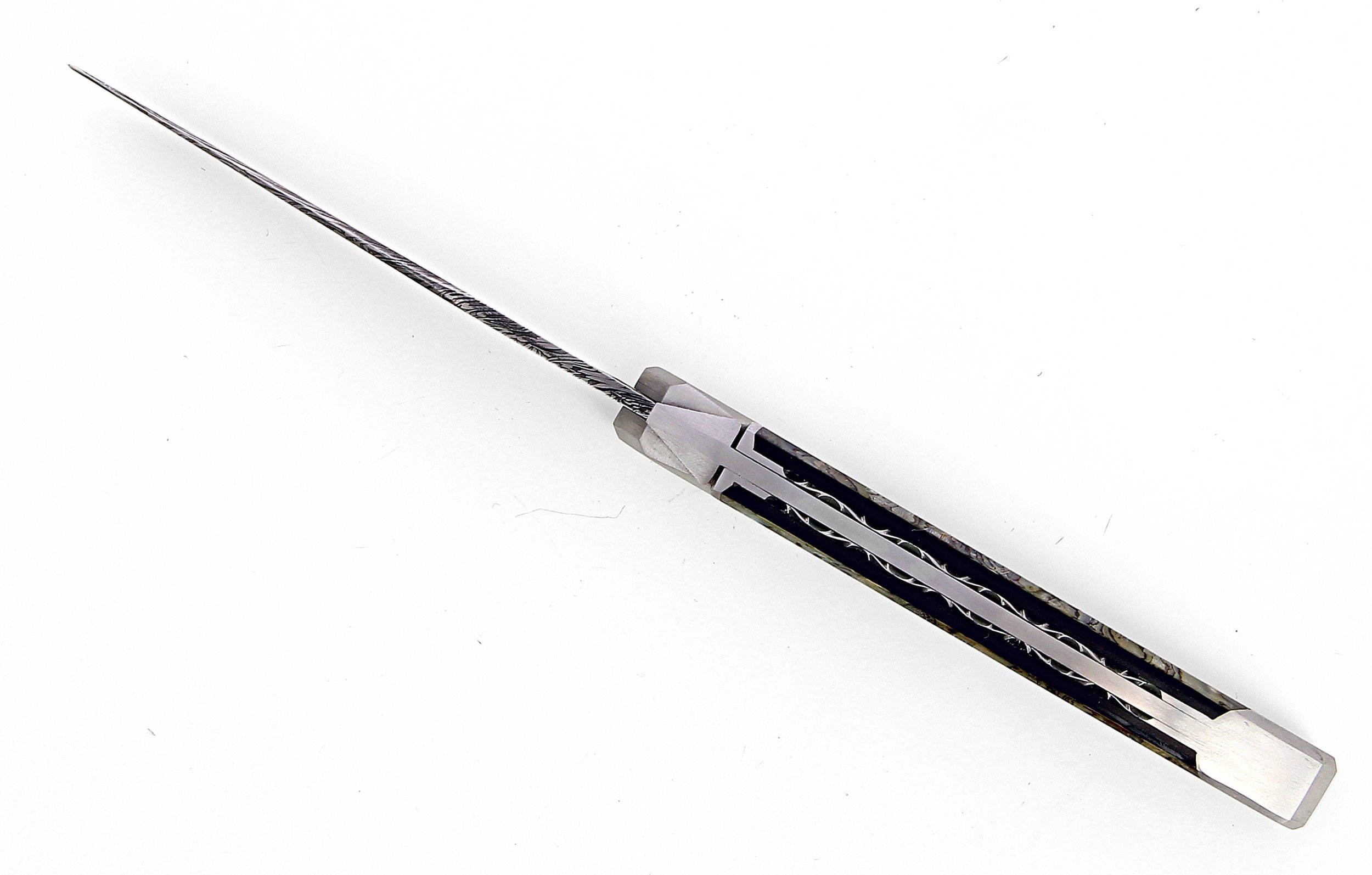 Ce couteau de Laguiole Tribal pliant est doté d'un manche de 12 cm en abalone protégé par deux mitres inox, et de platines guillochées.