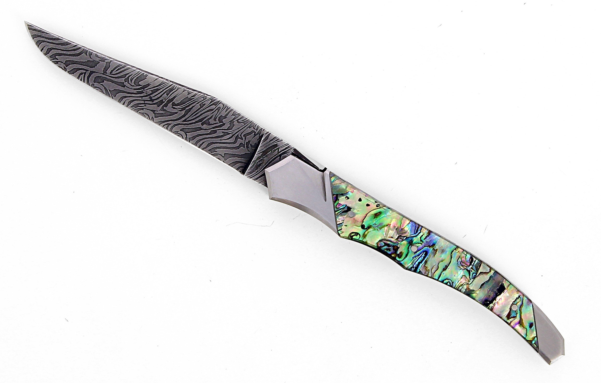Ce couteau de Laguiole Tribal pliant est doté d'un manche de 12 cm en abalone protégé par deux mitres inox, et de platines guillochées.