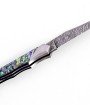 Ce couteau de Laguiole Tribal pliant est doté d'un manche de 12 cm en abalone protégé par deux mitres inox, et de platines guillochées.