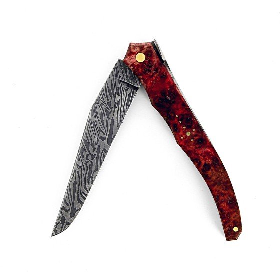 Ce couteau de Laguiole Tribal pliant est doté d'un plein manche de 12 cm en loupe d'erable négundo stabilisé, de platines guillochées et monté avec une lame damas carbone.